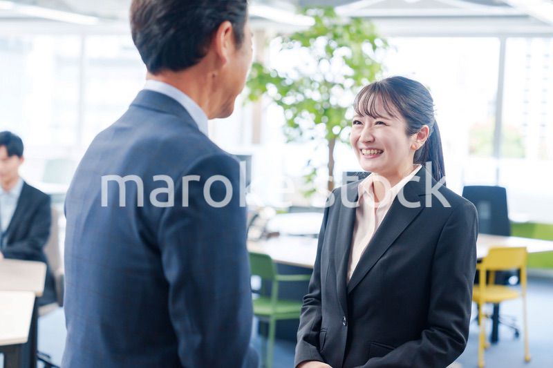 笑顔で上司と話をする若いビジネスウーマン