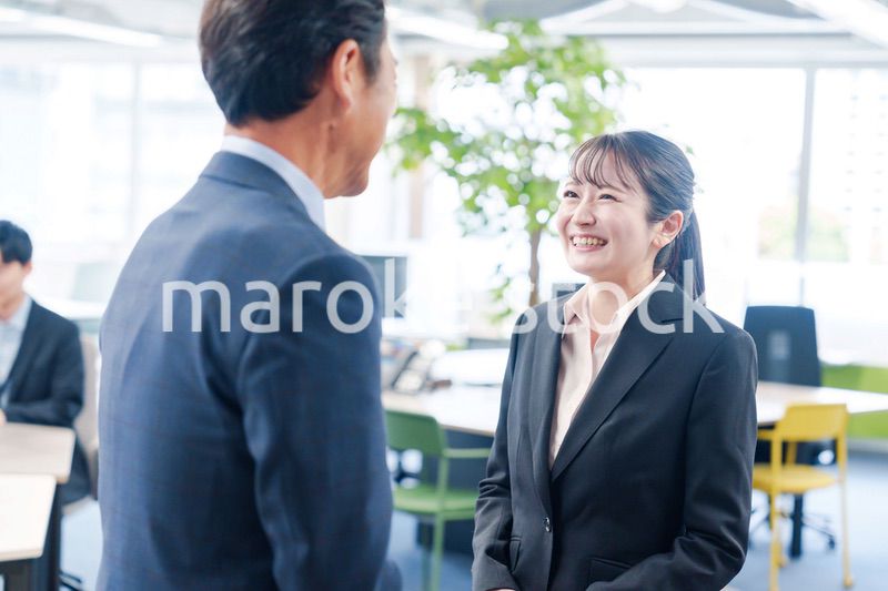 笑顔で上司と話をする若いビジネスウーマン