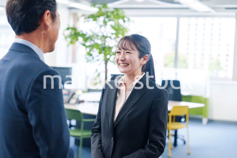 笑顔で上司と話をする若いビジネスウーマン