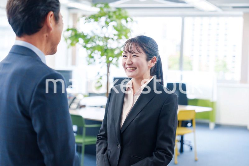 笑顔で上司と話をする若いビジネスウーマン
