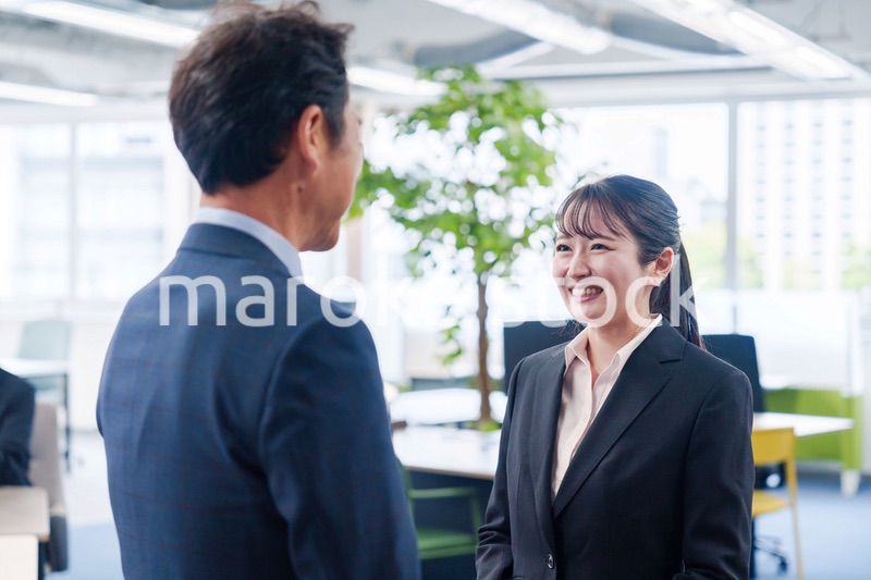 笑顔で上司と話をする若いビジネスウーマン