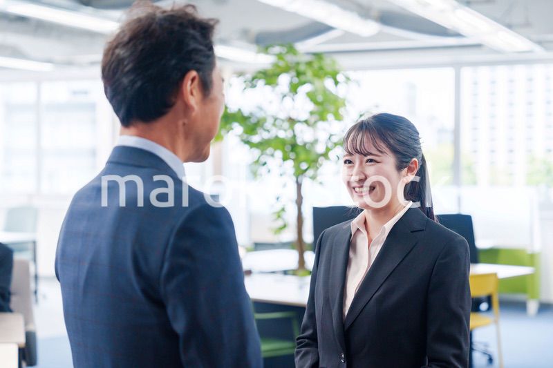 笑顔で上司と話をする若いビジネスウーマン