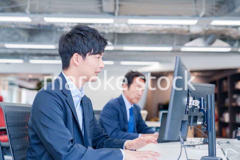 オフィスでモニタに向かって働くビジネスマン