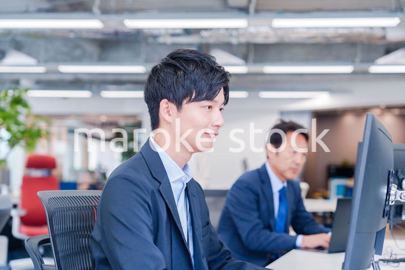 オフィスでモニタに向かって働くビジネスマン