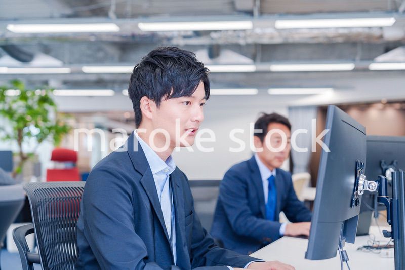 オフィスでモニタに向かって働くビジネスマン