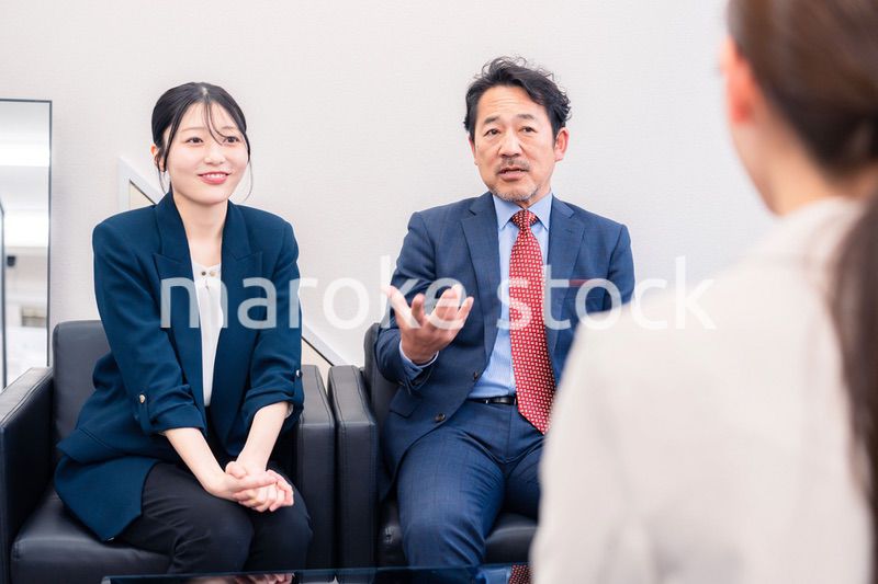 オフィスで楽しく会話をする中年男性とビジネスウーマン