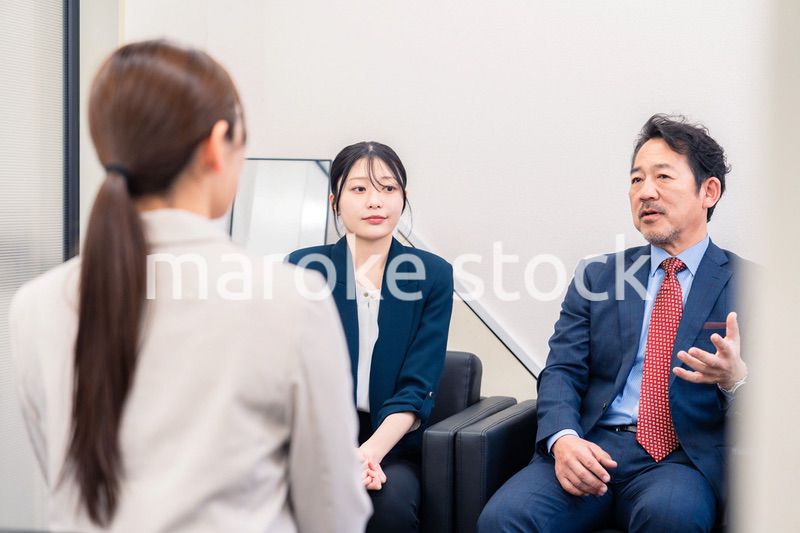 オフィスで楽しく会話をする中年男性とビジネスウーマン