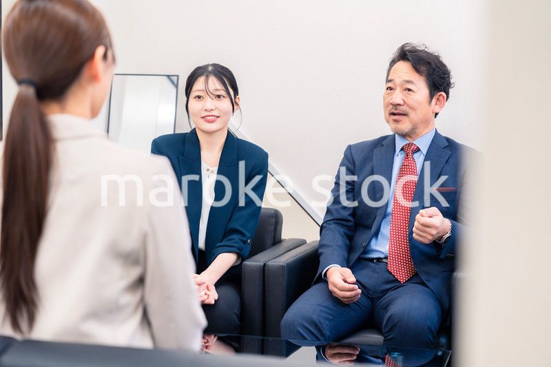 オフィスで楽しく会話をする中年男性とビジネスウーマン