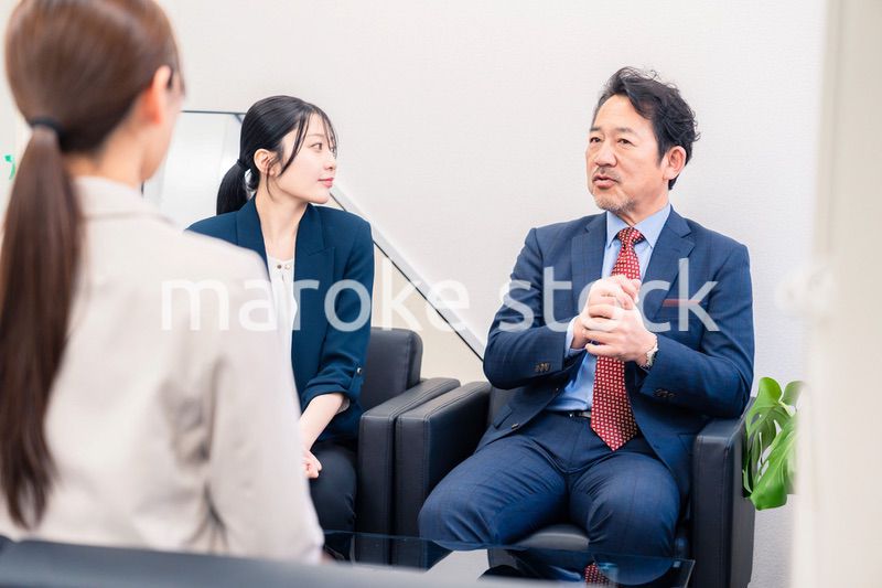 オフィスで楽しく会話をする中年男性とビジネスウーマン