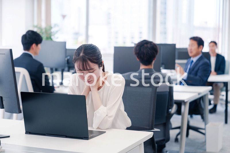 長時間のデスクワークで疲れたビジネスウーマン