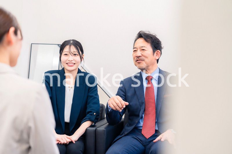 オフィスで楽しく会話をする中年男性とビジネスウーマン