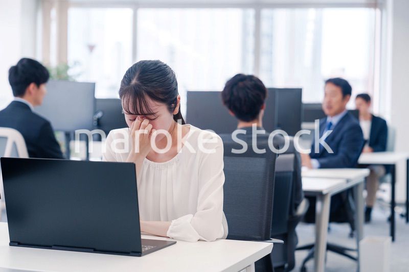 長時間のデスクワークで疲れたビジネスウーマン
