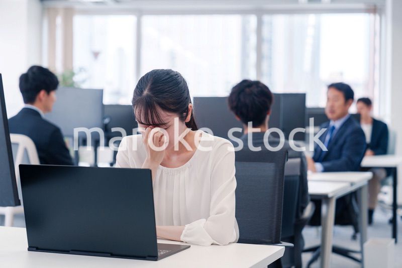 長時間のデスクワークで疲れたビジネスウーマン