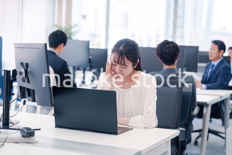 長時間のデスクワークで疲れたビジネスウーマン