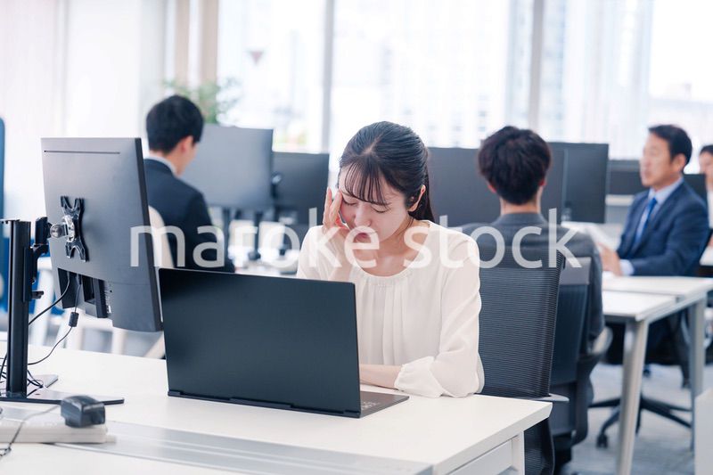 長時間のデスクワークで疲れたビジネスウーマン