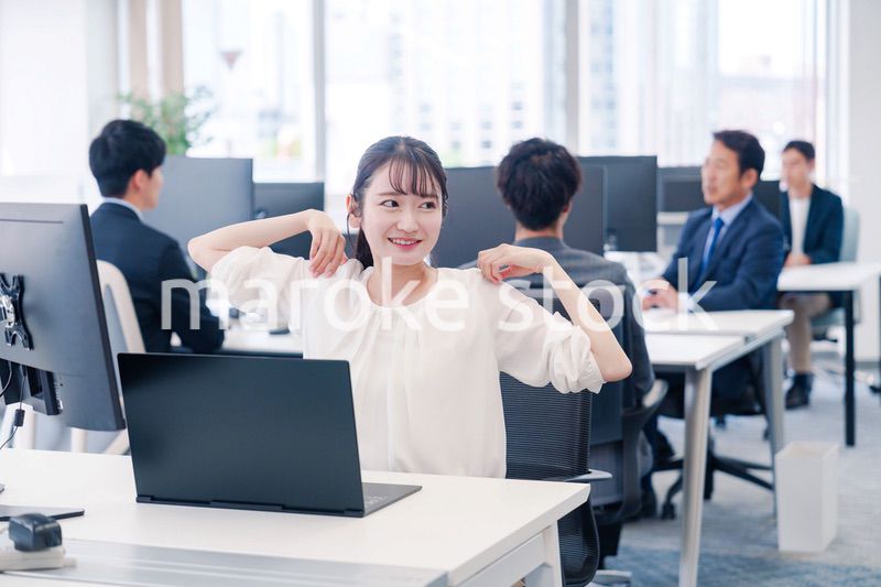 オフィスで伸びをしてリフレッシュするビジネスウーマン