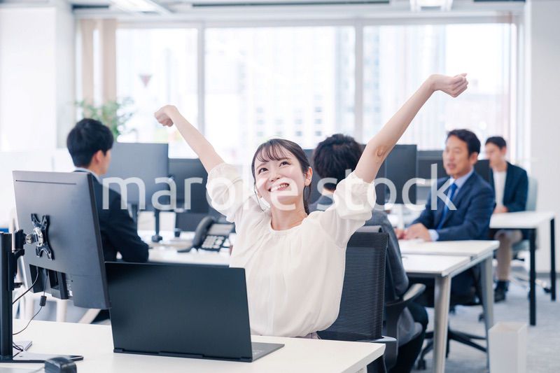 オフィスで伸びをしてリフレッシュするビジネスウーマン