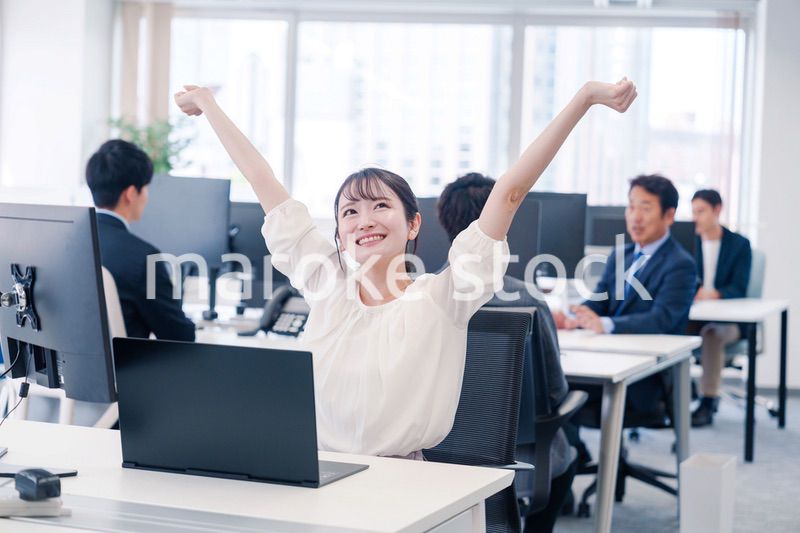 オフィスで伸びをしてリフレッシュするビジネスウーマン