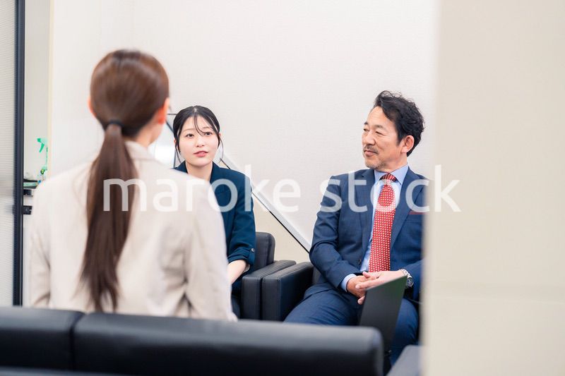 オフィスで楽しく会話をする中年男性とビジネスウーマン