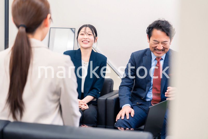 オフィスで楽しく会話をする中年男性とビジネスウーマン