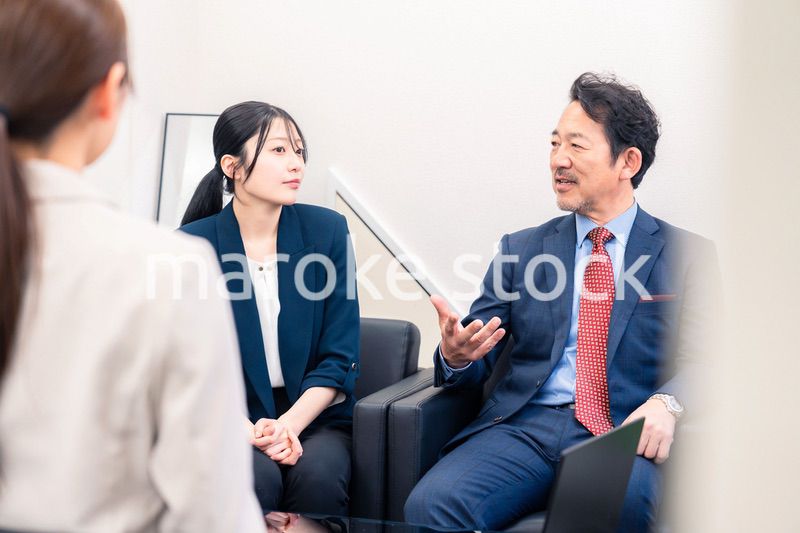 オフィスで楽しく会話をする中年男性とビジネスウーマン