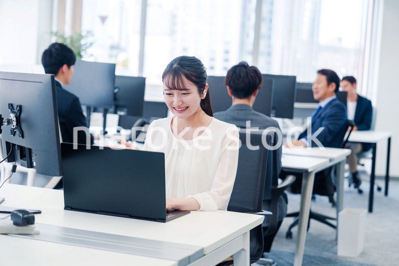 ワイヤレスイヤホンを使いオフィスでリモート会議をする女性