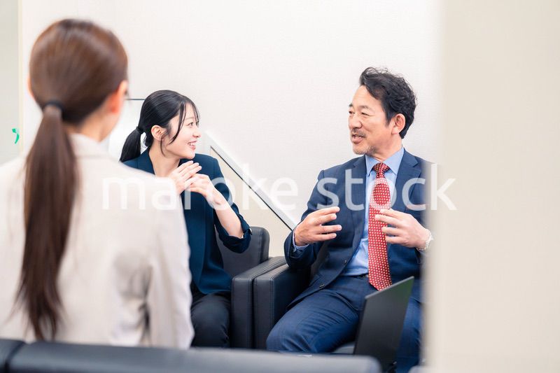 オフィスで楽しく会話をする中年男性とビジネスウーマン