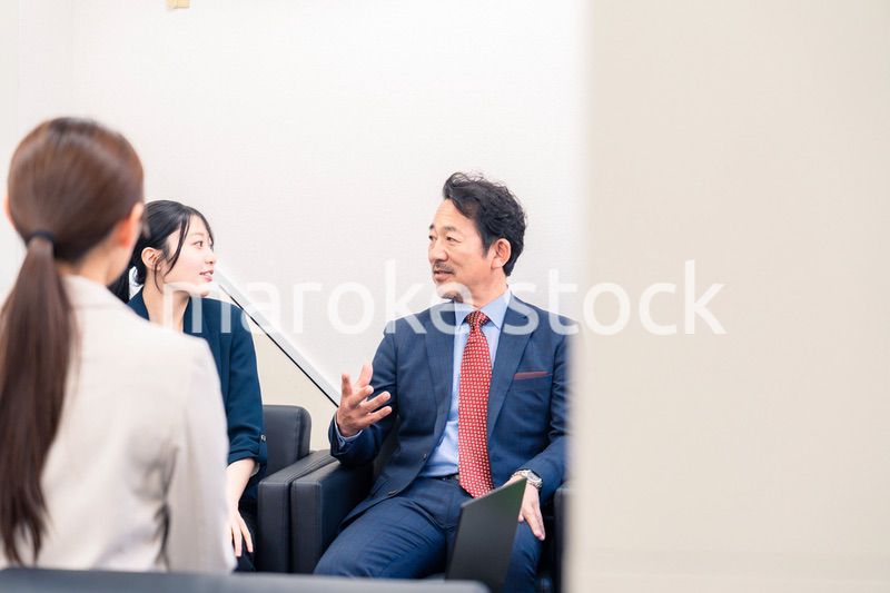 オフィスで楽しく会話をする中年男性とビジネスウーマン