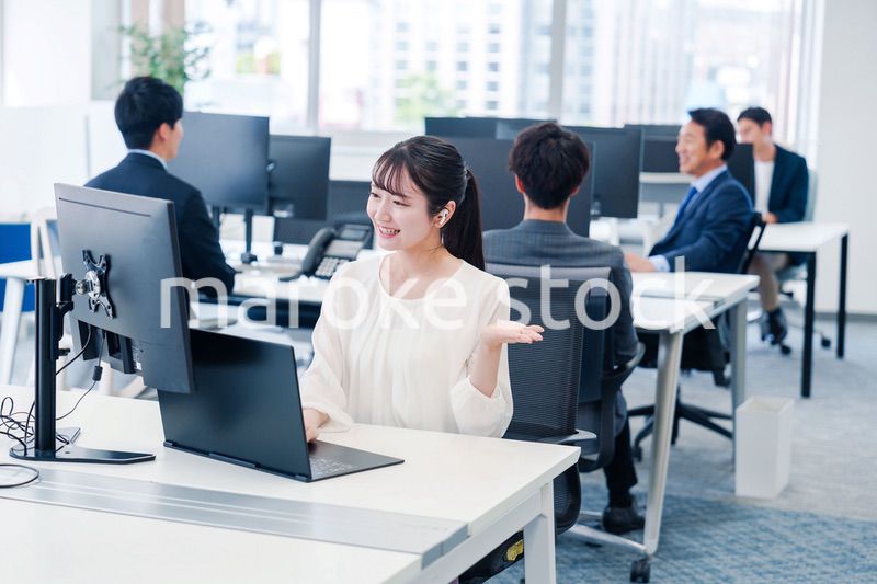 ワイヤレスイヤホンを使いオフィスでリモート会議をする女性