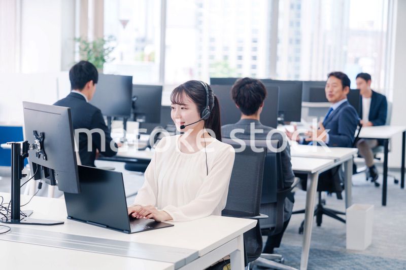 ヘッドセットをつけて話す若いビジネスウーマン