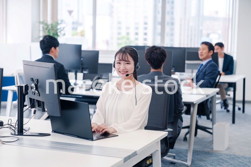 ヘッドセットをつけて話す若いビジネスウーマン