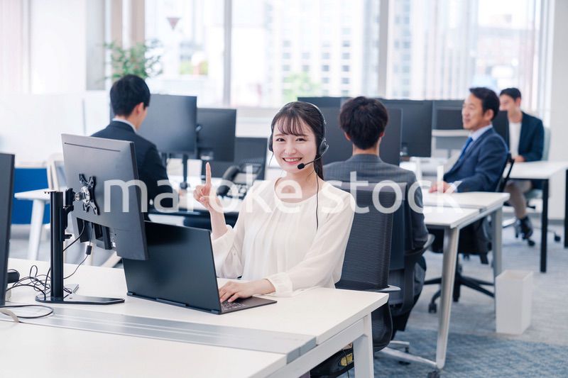 ヘッドセットをつけて話す若いビジネスウーマン