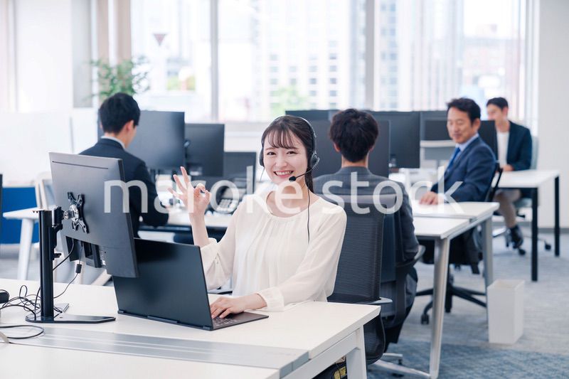 ヘッドセットをつけて話す若いビジネスウーマン