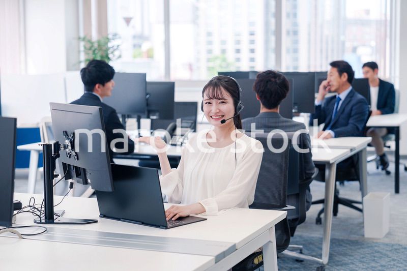 ヘッドセットをつけて話す若いビジネスウーマン