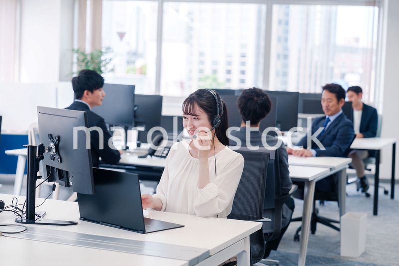 ヘッドセットをつけて話す若いビジネスウーマン