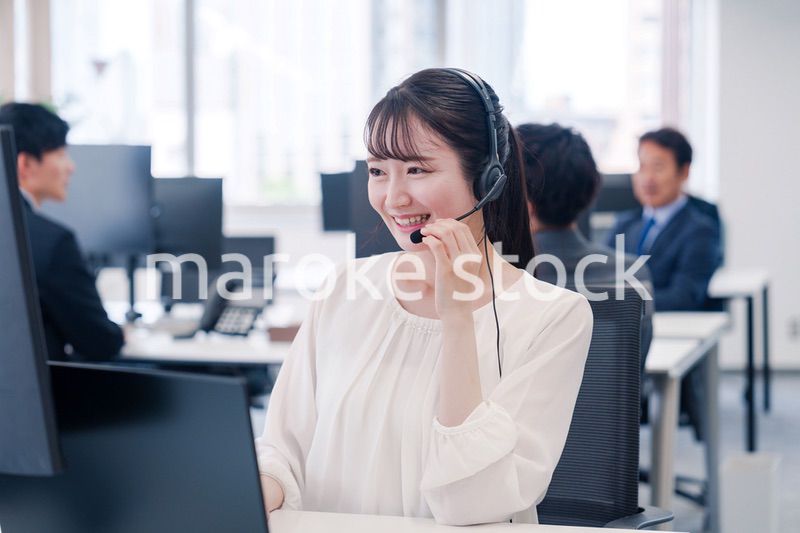 ヘッドセットをつけて話す若いビジネスウーマン