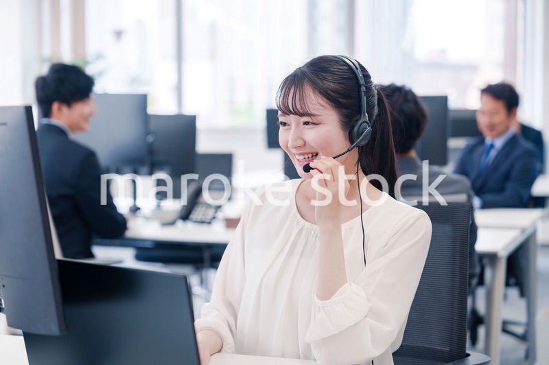 ヘッドセットをつけて話す若いビジネスウーマン