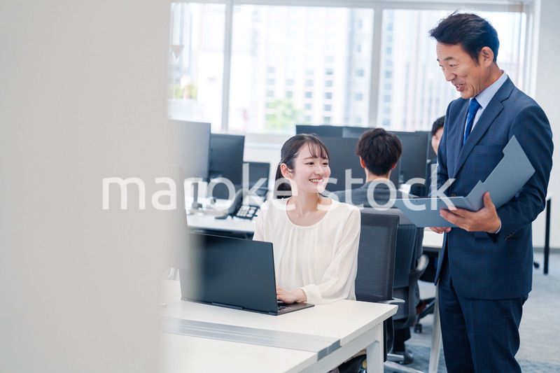 オフィスで上司と話をするビジネスウーマン
