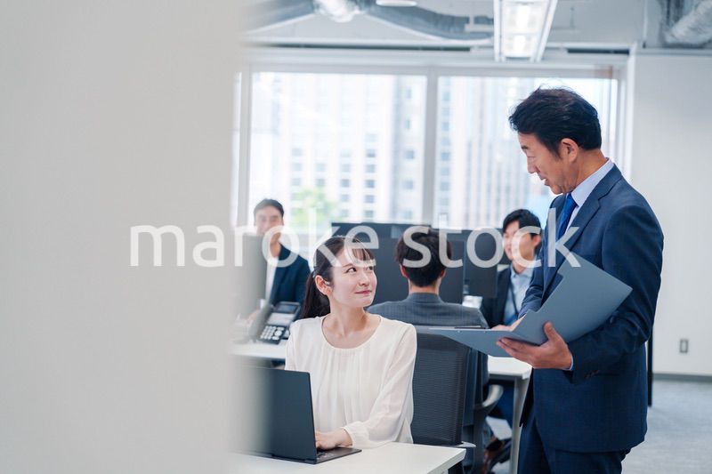 オフィスで上司と話をするビジネスウーマン