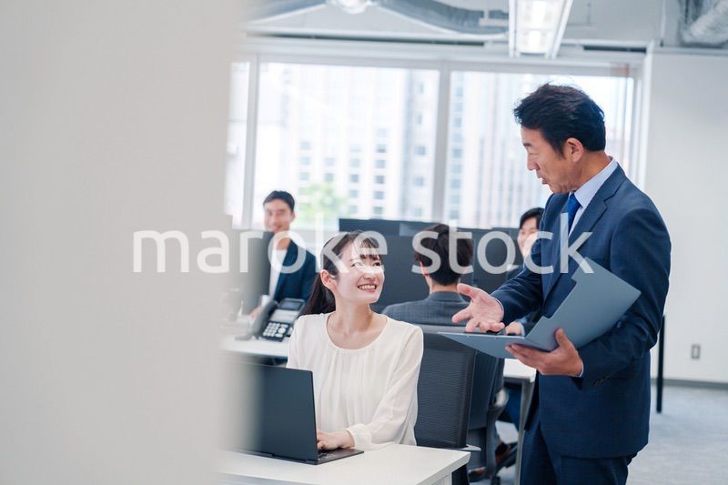 オフィスで上司と話をするビジネスウーマン