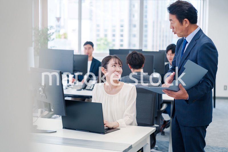 オフィスで上司と話をするビジネスウーマン