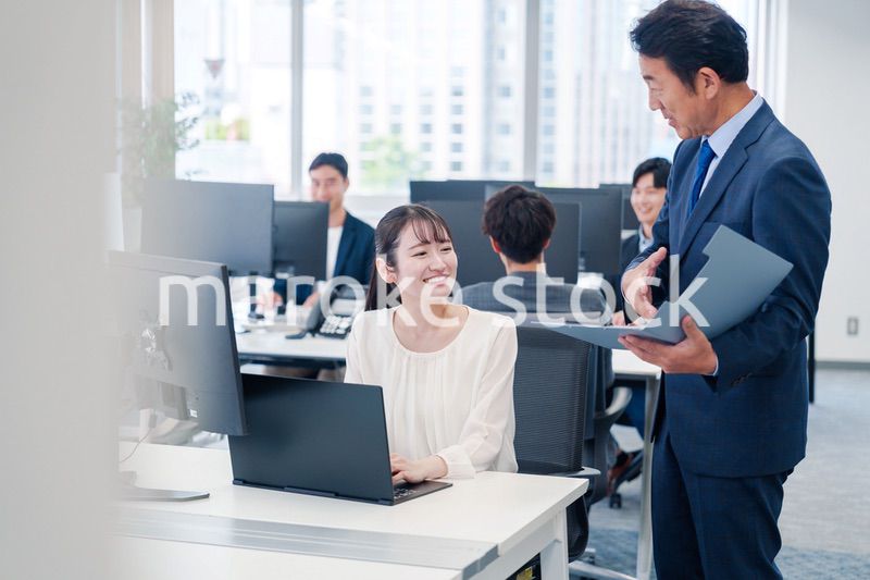 オフィスで上司と話をするビジネスウーマン