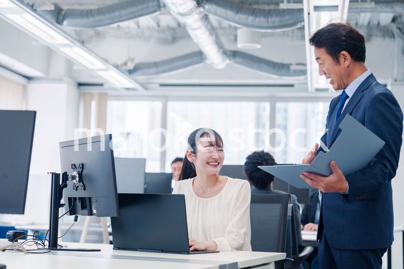 オフィスで上司と話をするビジネスウーマン