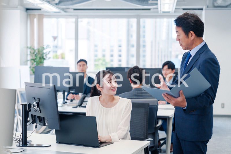 オフィスで上司と話をするビジネスウーマン
