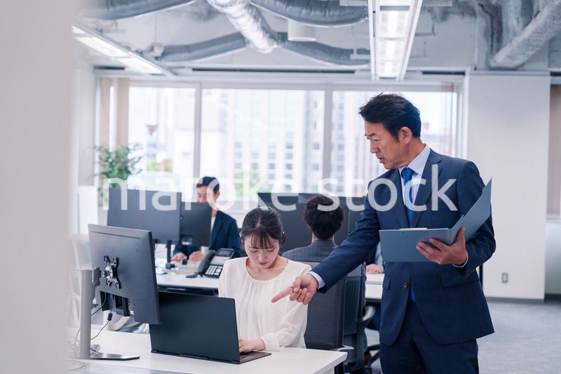 オフィスで上司から叱責をされる若い女性社員