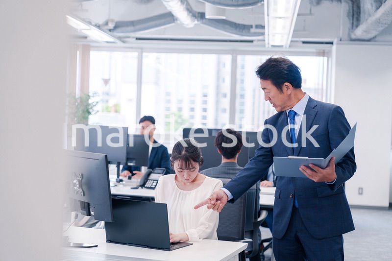 オフィスで上司から叱責をされる若い女性社員