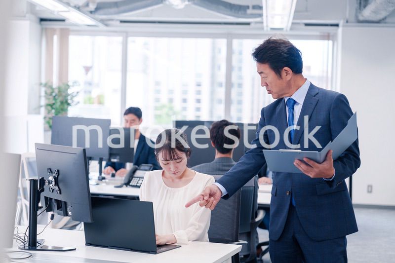 オフィスで上司から叱責をされる若い女性社員