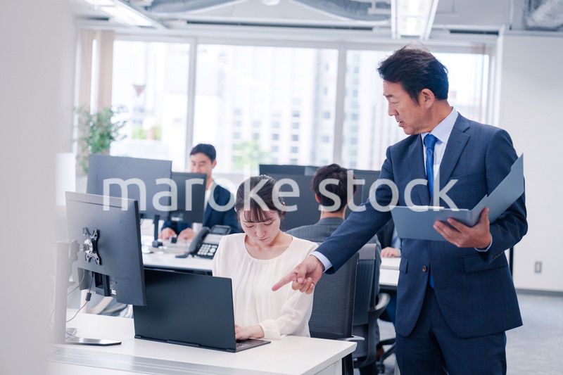 オフィスで上司から叱責をされる若い女性社員