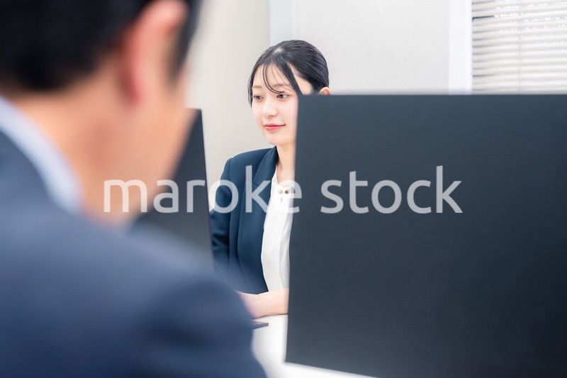 オフィスで生き生きとデスクワークをする若い女性