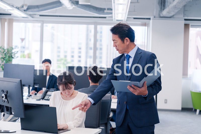 オフィスで上司から叱責をされる若い女性社員